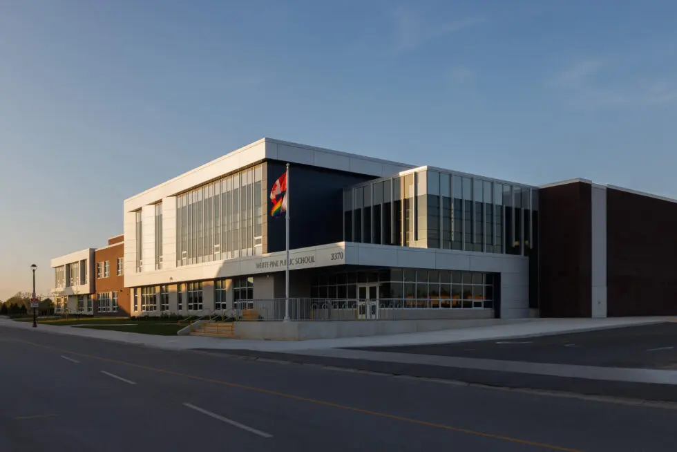 White Pine Public School modern building exterior with Canadian and Pride flags flying