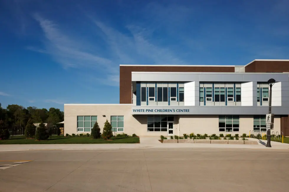 White Pine Children's Centre building exterior with modern design and clear blue sky, showing the entrance and windows.