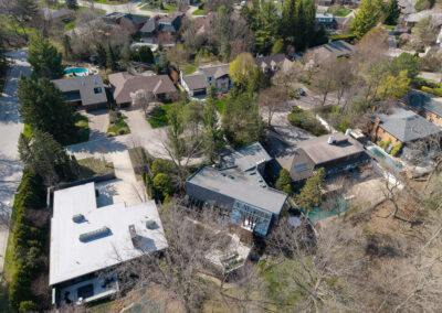 Aerial view of a diverse suburban neighborhood with modern and traditional homes, private pools, and lush trees.