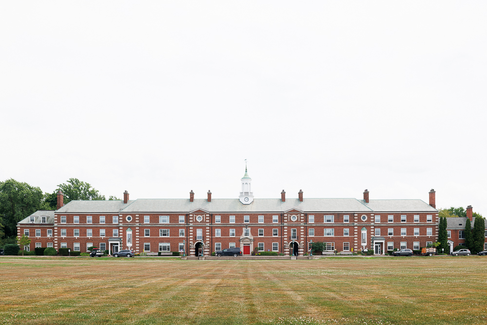 A wide-angle, symmetrical photograph of a historic red brick campus building with a central white clock tower at Ridley College.
