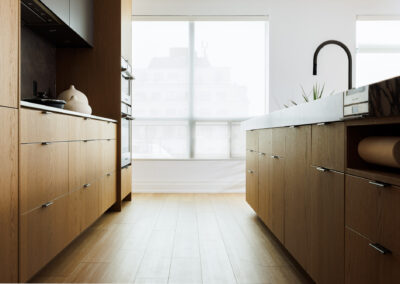 Modern kitchen with natural wood cabinets, white countertops, built-in appliances, and a large window with privacy blinds.