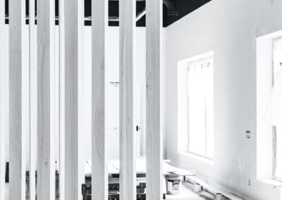 Black and white modern interior construction with vertical wooden slats, exposed industrial ceiling, and white walls